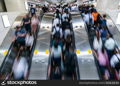 Crowd of Pedestrians Unrecognizable walking in escalator in rush hour morning before working time in subway transportation hub, Hong Kong, Central District, fast moving and business people concept