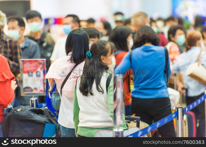 Crowd of people in masks waiting in airport during coronavirus quarantine