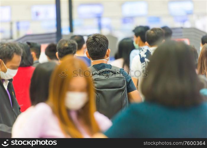 Crowd of people in masks waiting in airport during coronavirus quarantine
