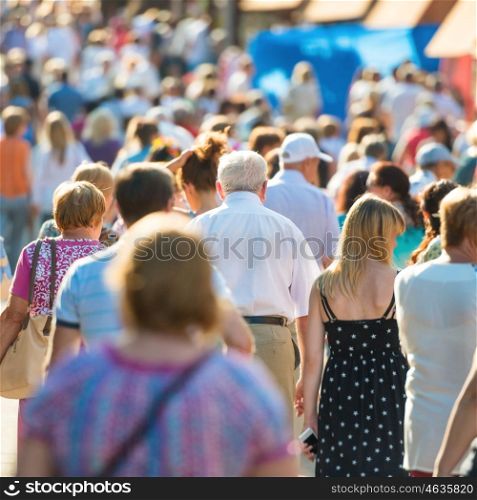 Crowd of people with old man in center walking on the busy city street