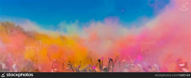 Crowd throwing bright colored powder paint in the air, The Color Run, Festival of joy