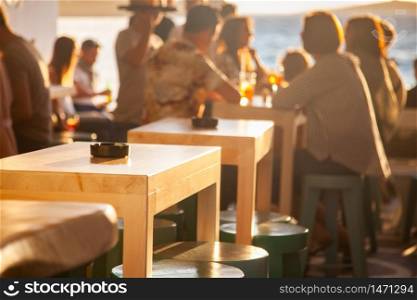 crowded restaurant by the beach at sunset