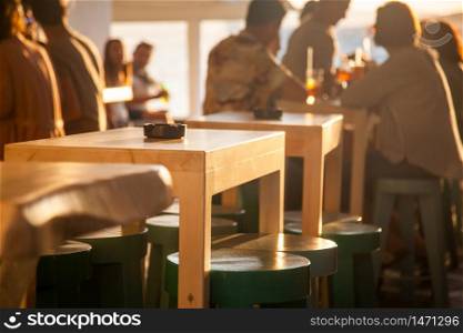 crowded restaurant by the beach at sunset