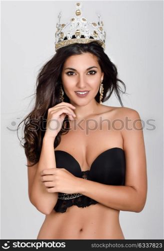 Crowned woman like miss of beauty looking at camera isolated on white background. Girl wearing crown, studio shot.