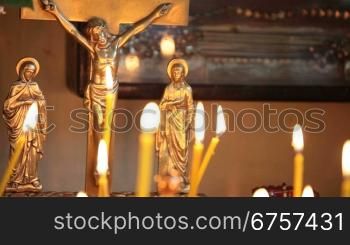 crucifix and burning candles in the church