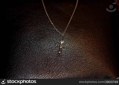 Crucifixion on the dark brown leather background