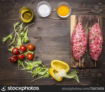 Crude kebab skewers on a chopping board with vegetables and spices on wooden rustic background top view close up place for text,frame