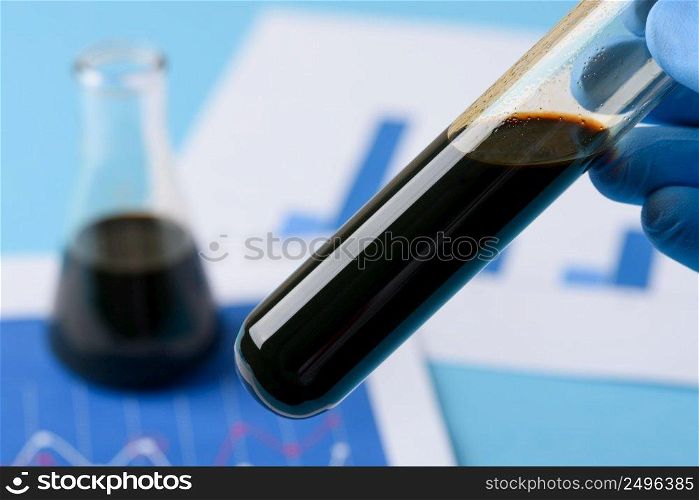 Crude oil in vial test tube in laboratory scientist hand.
