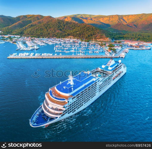 Cruise ship at harbor. Aerial view of beautiful large white ship at sunset. Landscape with boats, mountains, sea, blue sky. Top view of yacht. Luxury cruise. Floating liner in Europe. Travel. Resort. Aerial view of beautiful large white ship at sunset