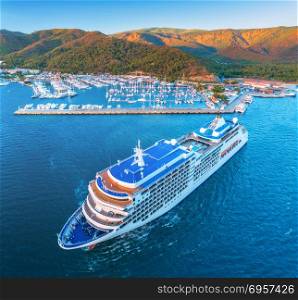 Cruise ship at harbor. Aerial view of beautiful large white ship at sunset. Landscape with boats, mountains, sea, blue sky. Top view of yacht. Luxury cruise. Floating liner in Europe. Travel. Resort. Aerial view of beautiful large white ship at sunset