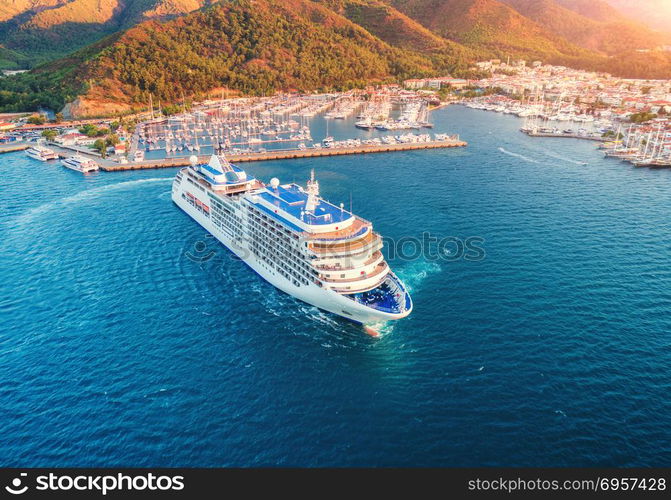 Cruise ship at harbor. Aerial view of beautiful large white ship at sunset. Landscape with boats, mountains, sea, blue sky. Top view of yacht. Luxury cruise. Floating liner in Europe. Travel. Resort. Aerial view of beautiful large white ship at sunset