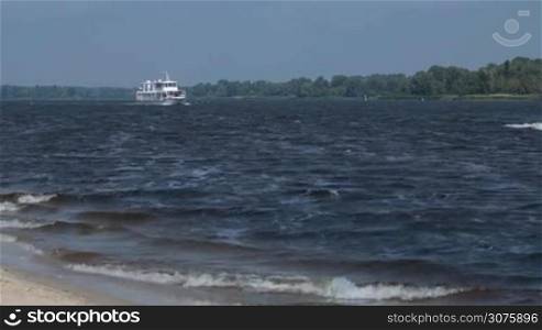 Cruise ship floating the river in summertime. Panoramic view of magnificent river from the bank
