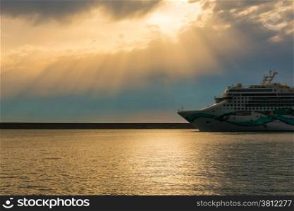 cruise ship in a cloudy sunset near the port