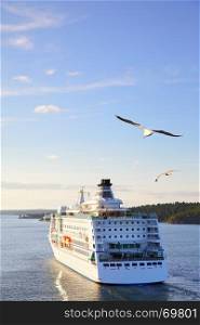 Cruise ship in the sea at sunset with flying gulls - Beautiful seascape. Copyspace composition
