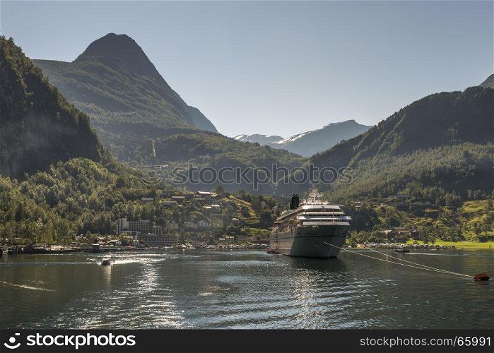 cruise ship on geirangerfjord in norway with snow on the hills in summer