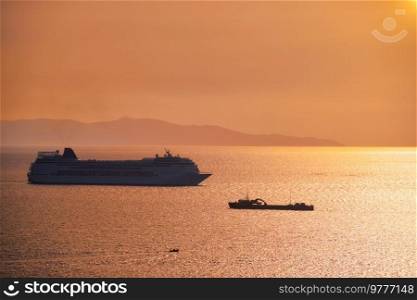 Cruise ship silhouette in Aegean sea on sunset. Mykonos island, Greece. Cruise ship silhouette in Aegean sea on sunset