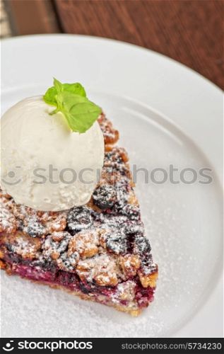 Crumble pie with black currants. English dessert with creamy ice cream