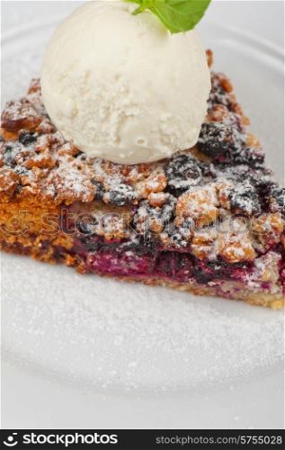 Crumble pie with black currants. English dessert with creamy ice cream. Crumble pie with black currants