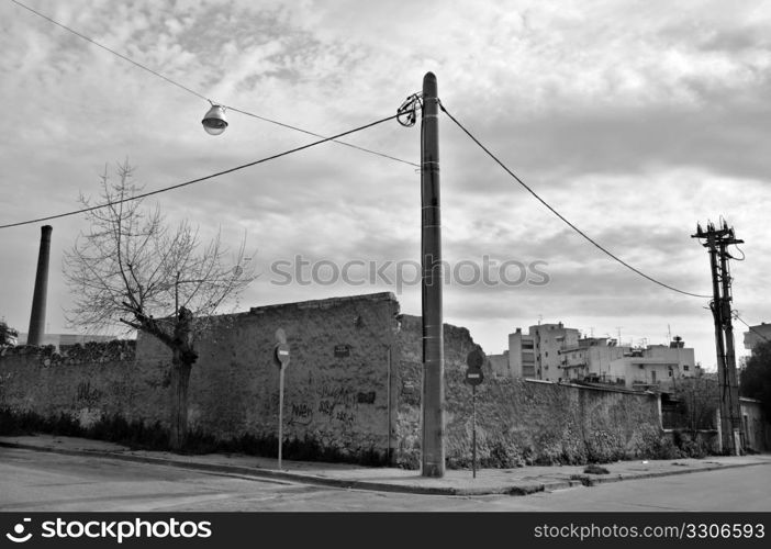 Crumbling factory wall and empty city steets. Black and white.