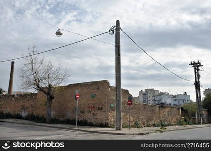 Crumbling factory wall and empty city steets. Industrial estate.