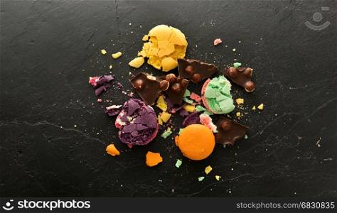 Crumbs of sweet macarons on a black stone table