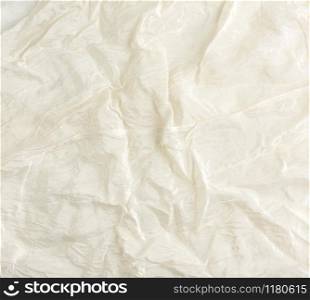 crumpled beige synthetic fabric for the manufacture of lining for skirts, full frame