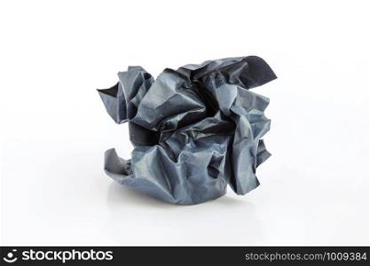 Crumpled black paper ball on a white background.