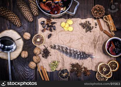 crumpled brown sheet of paper with a feather and ingredients for making a mulled wine drink, top view