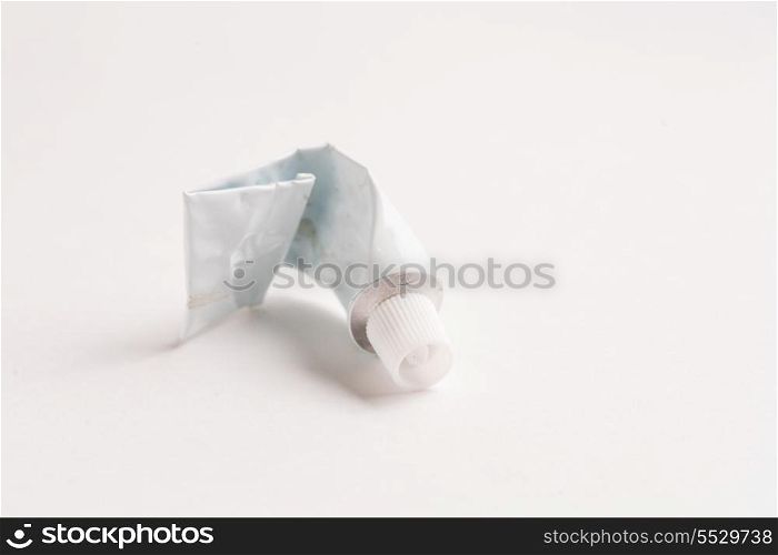 Crumpled emply tube of glue of white color