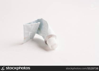 Crumpled emply tube of glue of white color