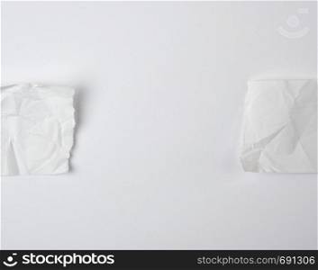 crumpled empty torn pieces of white paper on a white background, top view