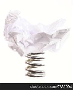 Crumpled paper ball on metal spring isolated on white background