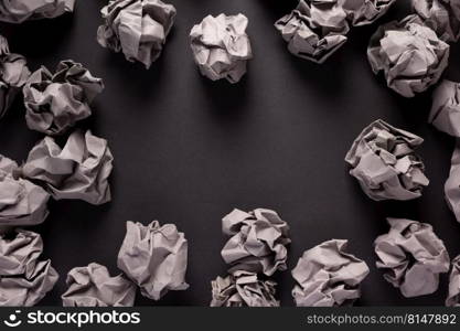 Crumpled paper balls at black background texture. Inspiration creative idea concept