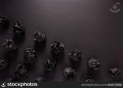 Crumpled paper balls at black background texture. Inspiration creative idea concept