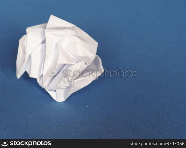 crumpled paper over blue background with copy space. white crumpled paper sheet over blue paper background with copy space