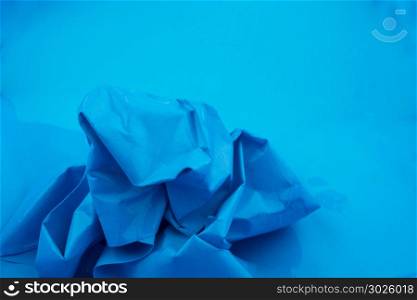 Crumpled paper put in water in blue background