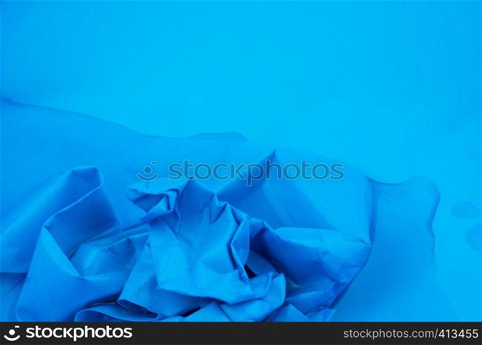 Crumpled paper put in water in blue background