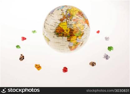 crumpled papers form a round shape around a globe. Colorful crumpled papers form a round shape around a globe on white background