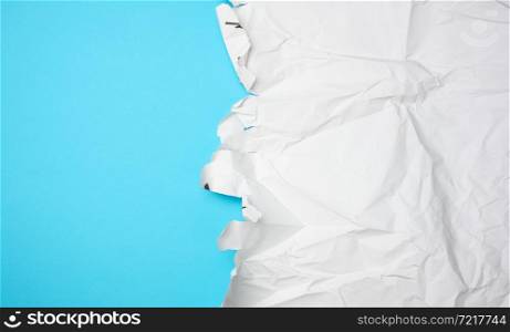 crumpled white paper with torn edges, blue background