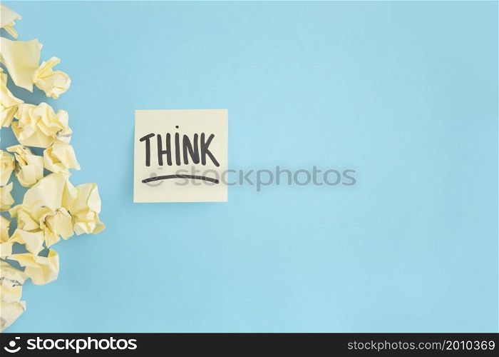 crumpled yellow paper with think witten text adhesive note blue background