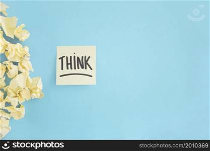 crumpled yellow paper with think witten text adhesive note blue background