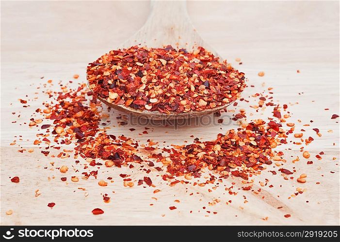 Crushed chillies on wooden serving spoon with shallow depth of field