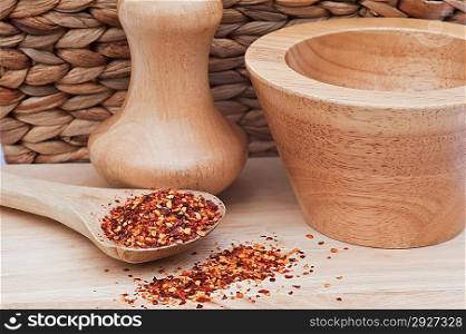 Crushed chillies on wooden spoon in rustic kitchen setting