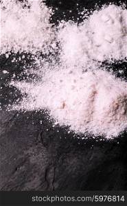 Crushed pink Himalayan salt on slate background. Pile Himalayan salt