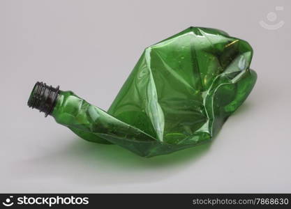 Crushed plastic bottle isolated on gray background