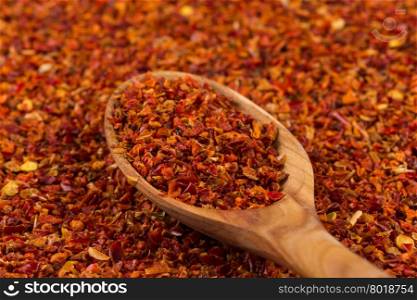 Crushed red chili pepper and wooden spoon