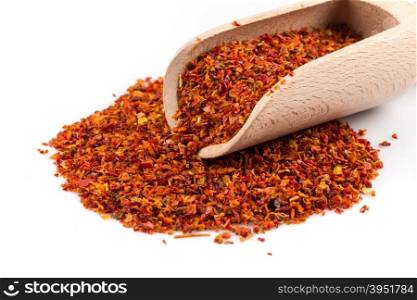 Crushed red chili pepper in spoon on white background