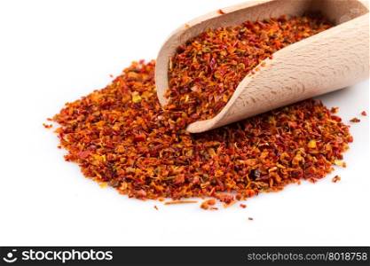 Crushed red chili pepper in spoon on white background