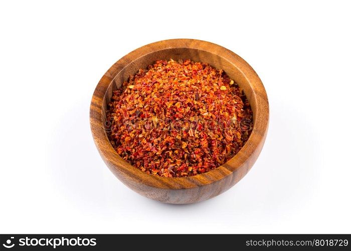 Crushed red chili pepper in wooden bowl on white background