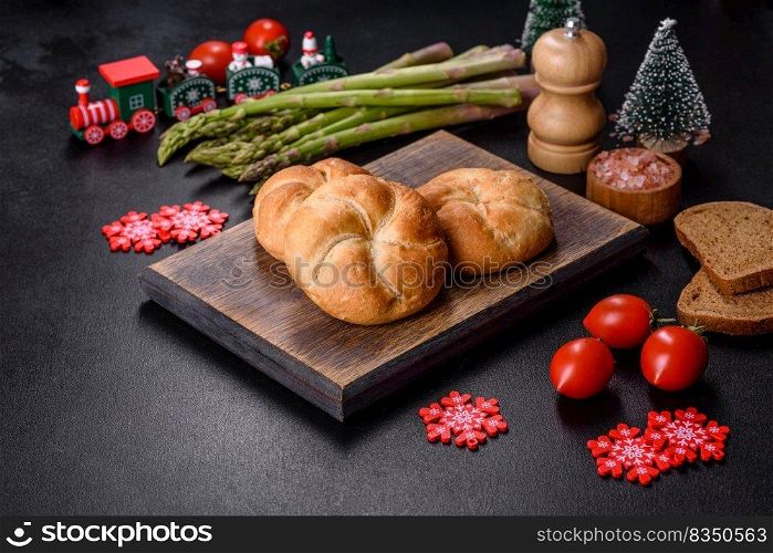 Crusty round bread rolls, known as Kaiser or Vienna rolls on a christmas table, flat lay on rustic background with text space. Crusty round bread rolls, known as Kaiser or Vienna rolls on a christmas table